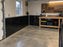 Garage with black HDPE wall liner installed along the lower walls beside a workbench and pegboard
